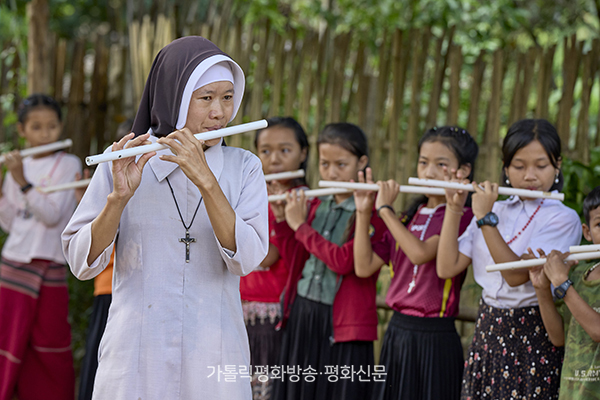 미얀마 국적의 스텔라 수녀가 난민촌에 개설한 학교에서 어린이들에게 플루트 강습을 하고 있다. 미얀마 로이카우교구 제공 