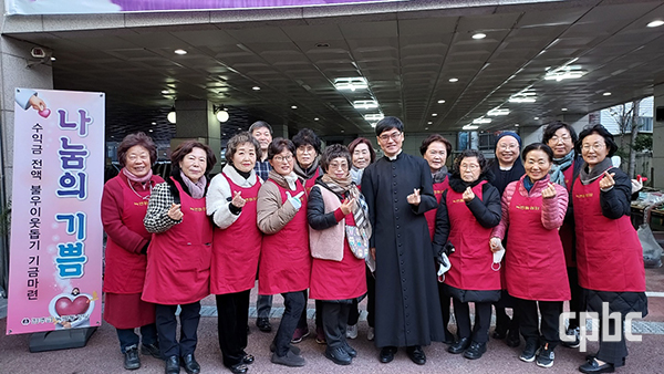 									서울 녹번동본당 나눔장터 봉사자들과 주임 김성권 신부가 사진을 찍고 있다.  녹번동본당 제공 								